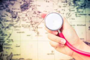 A travel nurse with Trusted Nurse Staffing holds a stethoscope in front of a map